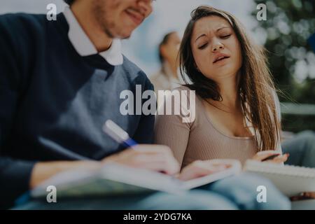 High school students collaborating with professor outdoors on assignments Stock Photo