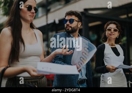 A group of young professionals engages in a lively discussion while standing outside. Stock Photo