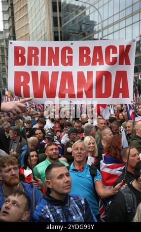 London, England, UK. 26th Oct, 2024. Thousands of protesters march along Victoria Street one with a sign saying ''˜Bring Back Rwanda'. Thousands of TOMMY ROBINSON supporters gather together and march from Victoria to Parliament Square in London. They had hoped that TOMMY would lead them but police arrested him on Friday 25th October for contempt of court following a previous showing of a film at a protest in London. (Credit Image: © Martin Pope/ZUMA Press Wire) EDITORIAL USAGE ONLY! Not for Commercial USAGE! Stock Photo