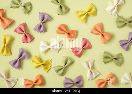Colored Farfalle pasta scattered on yellow background Stock Photo