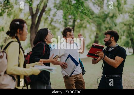Multicultural students discussing school assignments in a park setting Stock Photo