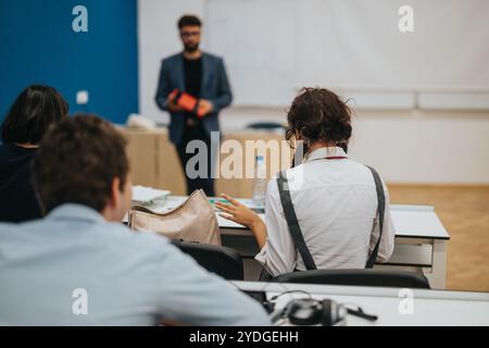 Students engaging in tasks with professor providing guidance in class Stock Photo
