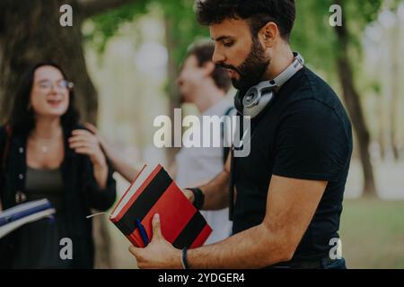 Multicultural students collaborating on school projects outdoors in a park setting Stock Photo