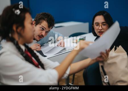 Students collaborating on assignments with professor assistance in class setting Stock Photo