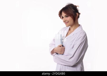 A Smiling Young Woman Dressed in a Lab Coat, Holding Several Notebooks with Care and Enthusiasm Stock Photo