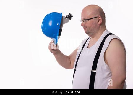 A worker is playfully holding a safety helmet, showcasing a fun and humorous moment Stock Photo