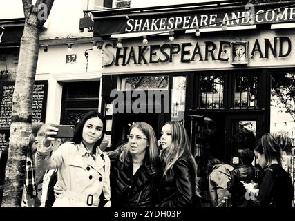 PARIS, FRANCE - SEPTEMBER 30, 2017: Tourists making selfie near the famous Shakespeare and Company bookstore. Black white historic photo. Stock Photo