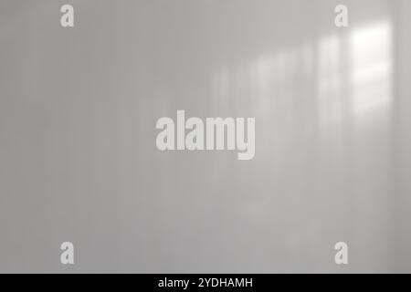 Light and shadow on an abstract gray background. Natural shadows and diagonal refraction of sunlight on a white concrete wall. Stock Photo