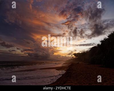 Beautiful sunset on the beach in Sri Lanka (Ceylon) with the waves and sandy coast, sunset or sunrise landscape with beautiful dramatic sky. Blue Indi Stock Photo