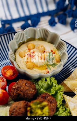 Creamy hummus topped with olive oil, chickpeas, and paprika. Perfect Middle Eastern dip Stock Photo