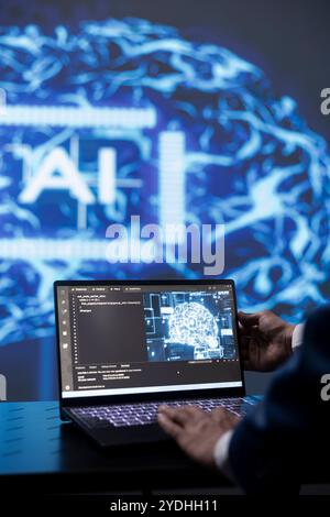 Admin at work running AI cognitive computing tech on laptop to simulate computerized model. Close up shot of worker typing code on notebook, using self learning algorithms to do data mining Stock Photo