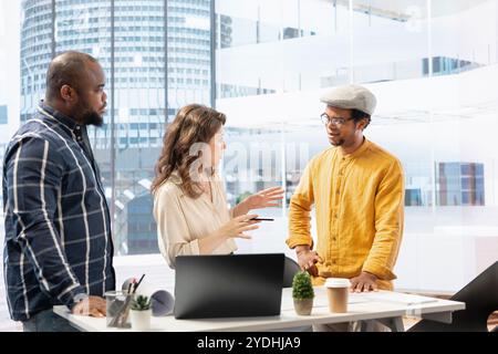 Business partners collaborating with a realtor contractor on office relocation, evaluating architectural plans of a high class building. Clients discussing real estate investment for a relocation. Stock Photo