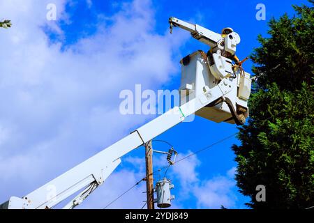 Works safely power line repairs being carried out with help of mobile lift. Stock Photo