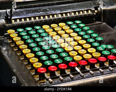 An old fashioned adding machine features a drawer located underneath it Stock Photo