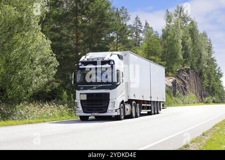 White Volvo FH truck pulls semi trailer along rural highway on a sunny day of summer. Salo, Finland. August 9, 2023 Stock Photo