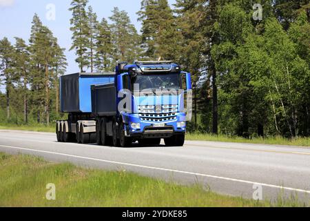 Blue Mercedes-Benz Arocs gravel truck and cassette trailer of Haenninen Group Oy on road in the summer. Copy space. Raasepori, Finland. June 10, 2021 Stock Photo