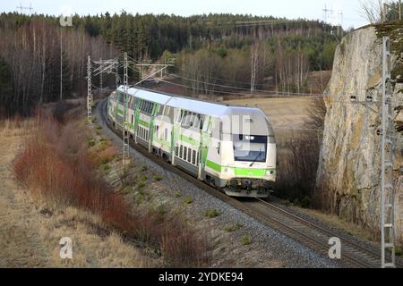 Modern VR Group electric 2 storey passenger train at speed in winter, elevated view from bridge. Salo, Finland. January 25, 2010 Stock Photo