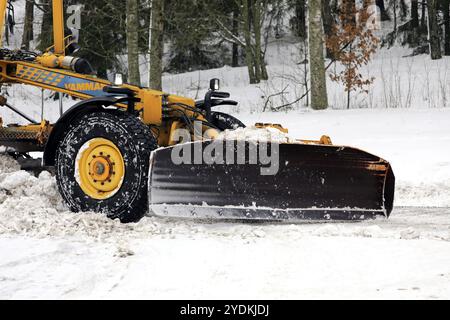 Yellow motor grader Vammas removing snow from street after heavy snowfall. Detail. Salo, Finland. January 22, 2021 Stock Photo