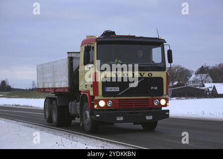 SALO, FINLAND, NOVEMBER 11, 2016: Volvo F12 hooklift dump truck moves along highway on a November winter night in South of Finland Stock Photo