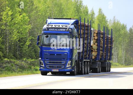 Jyvaskyla, Finland. June 7, 2019. Blue Volvo FH16 of Karjalaisen Puunkuljetus Oy pulls full timber trailer along highway on a beautiful day of summer Stock Photo