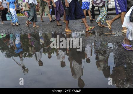 01.08.2013, Yangon, Myanmar, Asia, People walk along a street during the rainy season and are reflected in a huge puddle, Asia Stock Photo