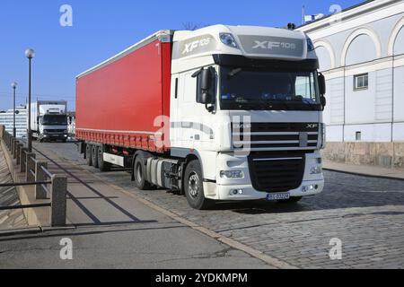 White DAF XF 105.460 semi trailer driving on cobbled Helsinki street after arrival in Port of Helsinki, Finland on sunny day of spring. April 7, 2020 Stock Photo