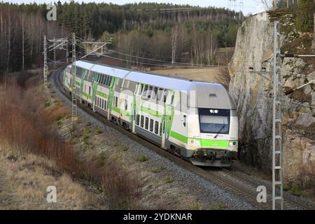 Modern VR Group electric 2 storey passenger train at speed in winter, elevated view from bridge. Salo, Finland. January 25, 2010 Stock Photo