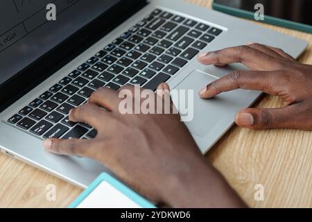 Hands Typing on Laptop Keyboard at Wooden Desk Stock Photo