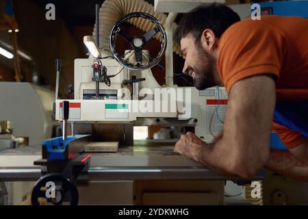 Woodworker using planer machine for production wooden materials specific size Stock Photo