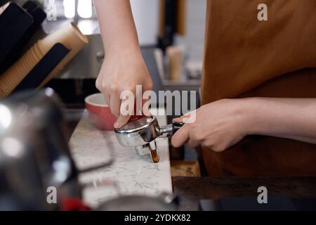 Cropped shot of woman barista making coffee, closeup view on hands Stock Photo