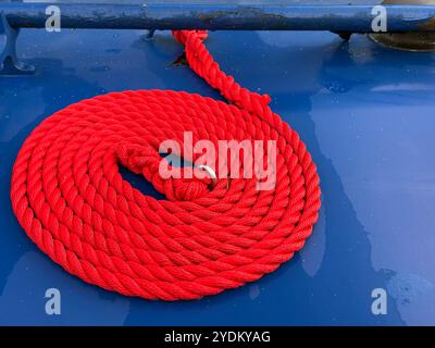 Red rope coiled into a circle on the blue painted roof of a narrowboat, Adlington, Lancashire Stock Photo