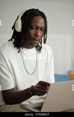 Focused Man Using Laptop with Headphones On Stock Photo