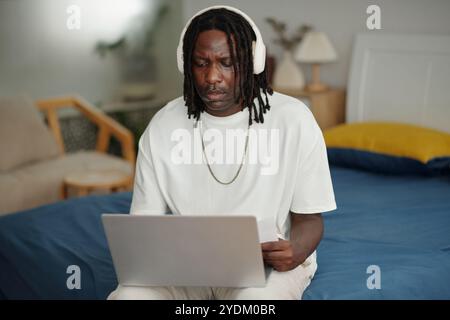 Focused Man Using Laptop at Home Office Setting Stock Photo
