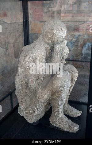 Plaster cast of a victim of the eruption in the Macellum (marketplace) in the ruins of the ancient city of Pompeii in Campania Region, Southern Italy Stock Photo