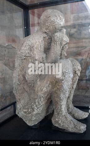 Plaster cast of a victim of the eruption in the Macellum (marketplace) in the ruins of the ancient city of Pompeii in Campania Region, Southern Italy Stock Photo