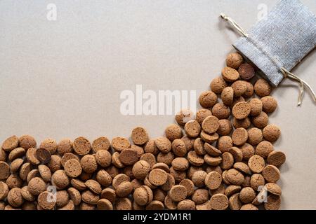 Many kruidnoten falling from the small jute bag, dutch cookie made of speculaas and traditionally associated with Sinterklaas Holiday Stock Photo