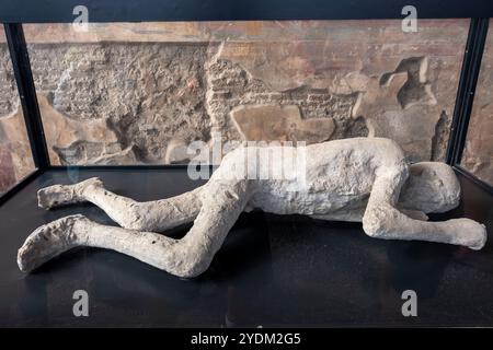 Plaster cast of a victim of the eruption in the Macellum (marketplace) in the ruins of the ancient city of Pompeii in Campania Region, Southern Italy Stock Photo