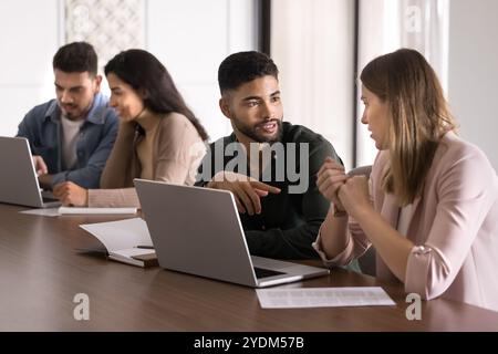 Serious young Arabic mentor training intern at laptop Stock Photo