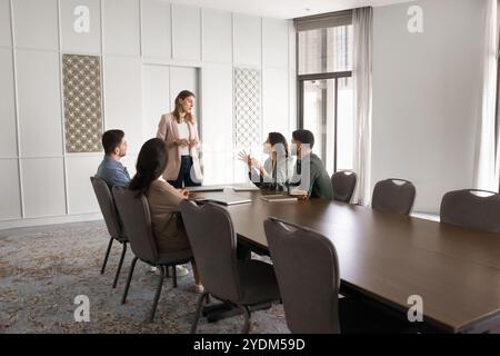 Serious female boss standing at large office meeting table Stock Photo