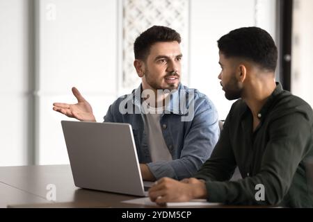 Confident young Middle Eastern startup leader man talking to partner Stock Photo