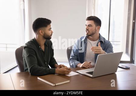 Confident engaged young Arabic business partners working on online startup Stock Photo