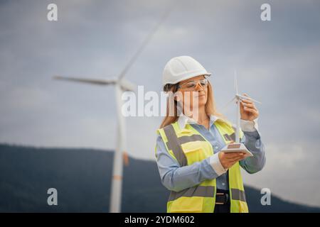 A female engineer is actively engaged in conducting maintenance on a wind turbine within the renewable energy sector, showcasing her expertise and Stock Photo