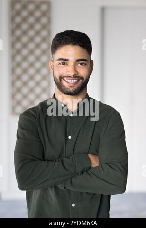 Confident young Arabian business leader man posing with hands folded Stock Photo