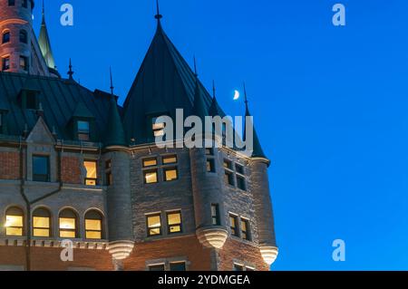 the historic chateau frontenac in Quebec City Canada with crescent moon in the sky. Stock Photo