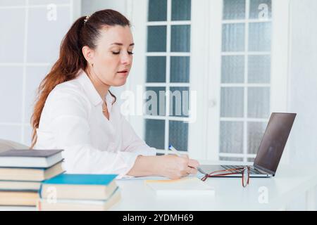 woman working online with laptop at desk in office Stock Photo