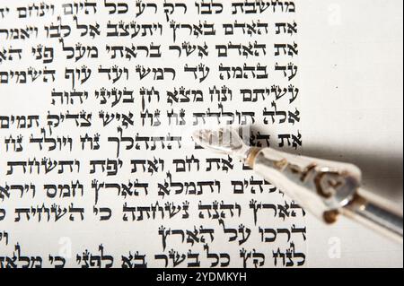 A silver yad points to the opening verse of the portion of Noach in theHebrew Bible, showing the first words of the story from the first book of the T Stock Photo