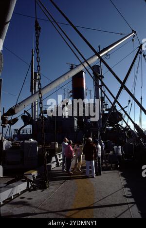 San Pedro, CA. USA. 1983. Lane Victory was built in Los Angeles by the California Shipbuilding Corporation and launched on May 31, 1945. On her first voyage, June 27, 1945, Lane Victory carried war supplies in the Pacific. The War Shipping Administration gave the operations of the ship to the American President Lines. United States Merchant Mariners operated the ship. The United States Navy Armed Guard, who manned the ship's guns, worked as signalmen and radiomen. She made two Pacific cruises, beginning July 10, 1945, to Manus Island, and the second starting August 30, 1945, to Guam, Saipan Stock Photo