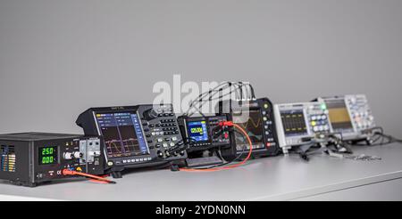 Various measuring devices and oscilloscopes set up on a work table in a work situation Stock Photo