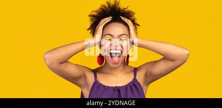Happy afro woman screaming and grabbing head Stock Photo