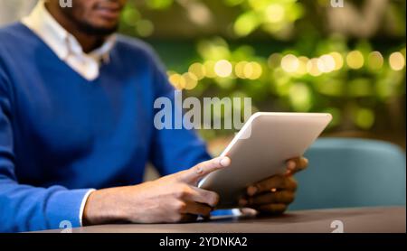 Black guy sitting in coffee shop working on tablet Stock Photo